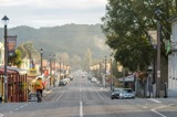 View looking down the main street of a small town with a cyclist and historic buildings