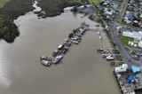 Aerial drone shot looking over a small fishing port with marina berths and commercial wharves